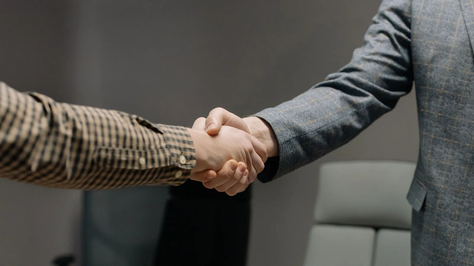 Two business people shaking hands in an office.
