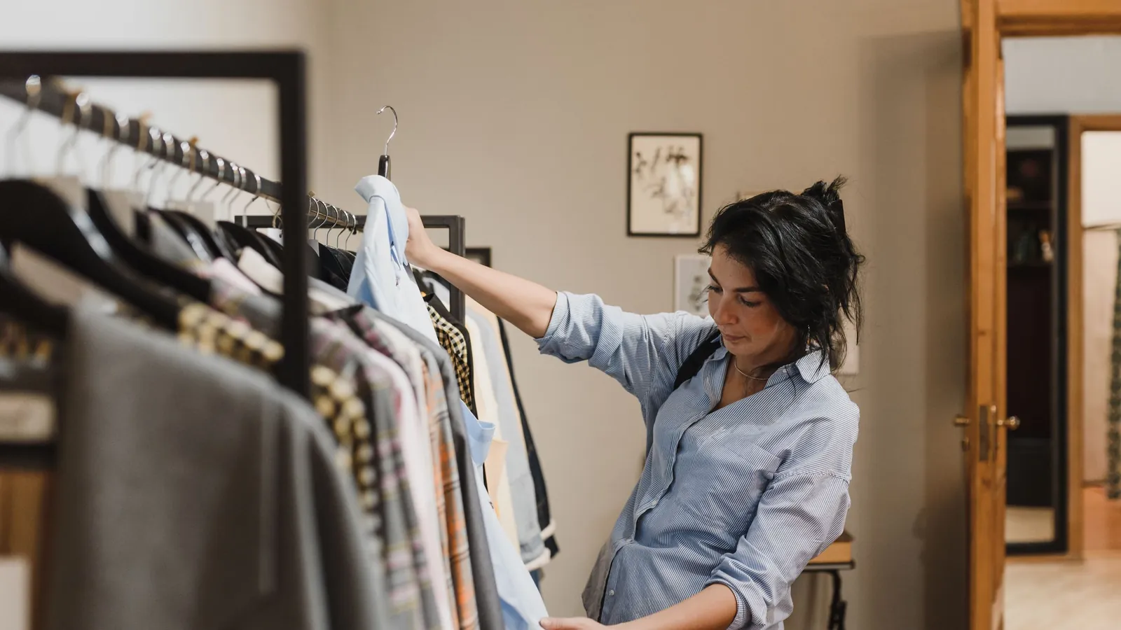 A shopper looking through a clothing rack in a small boutique.
